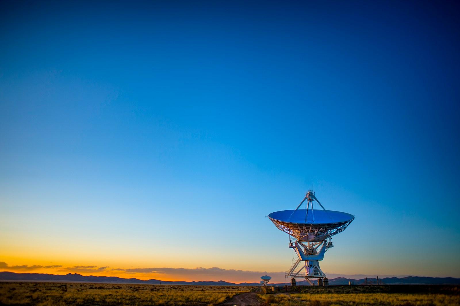 A satellite dish against a sunset sky